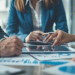 Men, woman and tablet at business meeting in office planning, goals or mission at desk with strategy. Teamwork, touchscreen or leadership for vision, collaboration and coaching in financial company